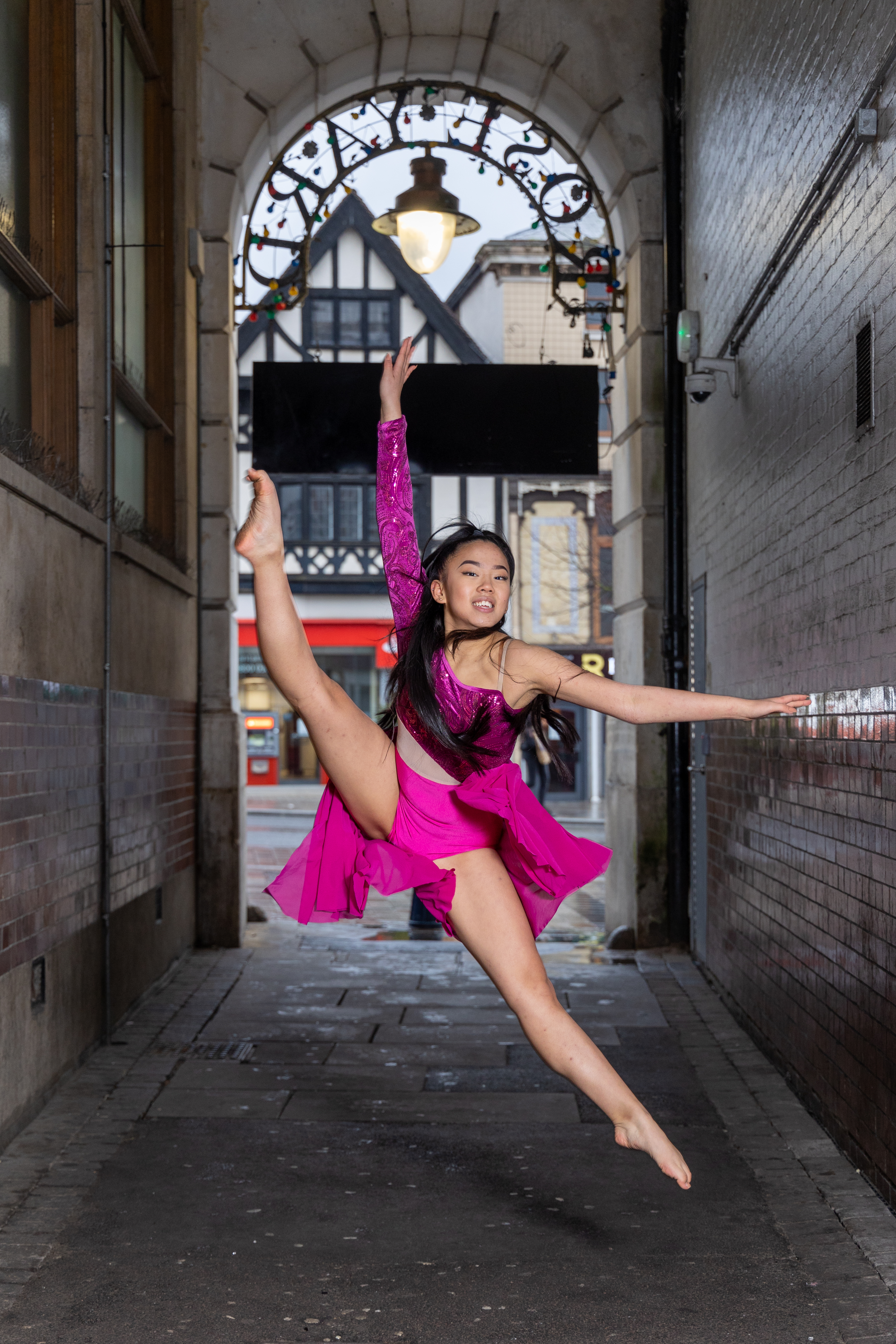 HI Dancer in mid air dance move in two piece fuchsia pink outfit