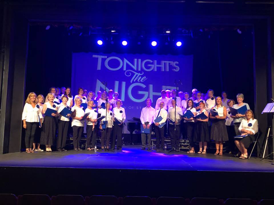 HI Choir on the Hazlitt Theatre Stage with a background that says Tonight's The Night